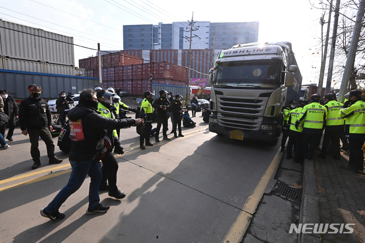 [의왕=뉴시스] 김종택기자 = 공공운수노조 화물연대가 안전운임 일몰제 폐지 등을 요구하며 총파업에 돌입한 25일 오전 경기도 의왕 내륙컨테이너기지에서 조합원들이 파업 참여를 요구하며 실랑이가 벌어지자 경찰이 제지하고 있다. 2021.11.25. jtk@newsis.com