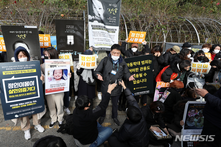 [서울=뉴시스] 조성우 기자 = 생후 16개월 된 정인양을 학대해 숨지게 한 혐의를 받는 양모가 2심 선고 공판에서 감형을 받은 26일 서울 서초구 서울고등법원 앞에서 시민들이 손팻말을 들고 항의하고 있다. 2021.11.26. xconfind@newsis.com