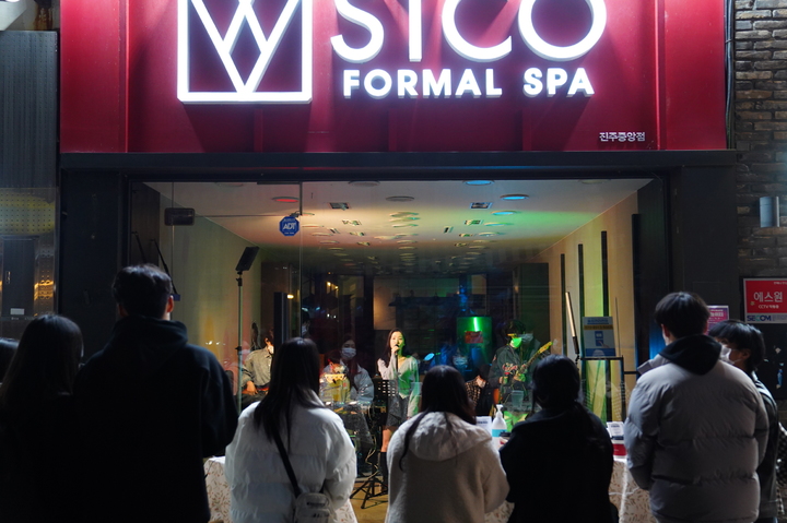 [진주=뉴시스] 진주시와 진주문화도시지원센터는 대안동 차없는거리 가면 건물 앞에서 쇼윈도 버스킹 및 이어폰서트 공연을 관객들이 공연을 즐기는 모습이다. *재판매 및 DB 금지