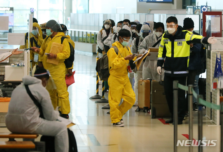 [인천공항=뉴시스] 배훈식 기자 = 코로나19 변이 바이러스 오미크론 유입 차단을 위해 남아공 등 8개국 발 외국인 입국이 제한된 29일 오전 인천국제공항 제1터미널에서 방호복을 착용하고 입국한 외국인들이 행선지 이동 수단 등을 확인하기 위해 대기하고 있다. 2021.11.29. dahora83@newsis.com