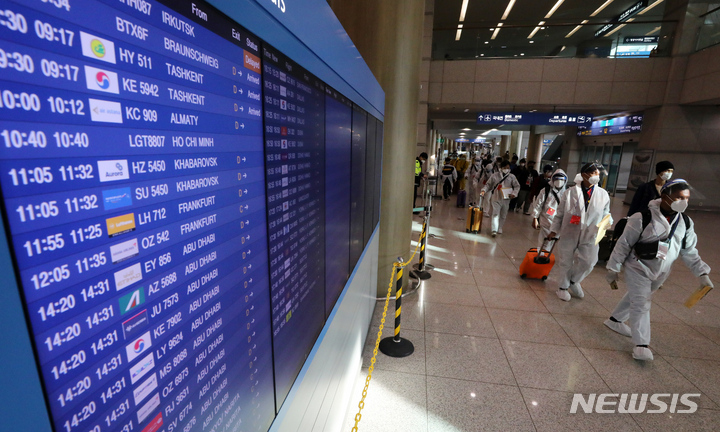 [인천공항=뉴시스] 배훈식 기자 = 코로나19 변이 바이러스 오미크론 유입 차단을 위해 남아공 등 8개국 발 외국인 입국이 제한된 29일 오전 인천국제공항 제1터미널에서 방호복을 착용하고 입국한 외국인들이 이동하고 있다. 2021.11.29. dahora83@newsis.com