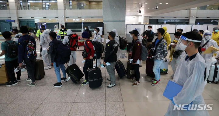 [인천공항=뉴시스] 배훈식 기자 = 코로나19 변이 바이러스 오미크론 유입 차단을 위해 남아공 등 8개국 발 외국인 입국이 제한된 29일 오전 인천국제공항 제1터미널에서 방호복을 착용하고 입국한 외국인들이 행선지 이동 수단 등을 확인하기 위해 대기하고 있다. 2021.11.29. dahora83@newsis.com