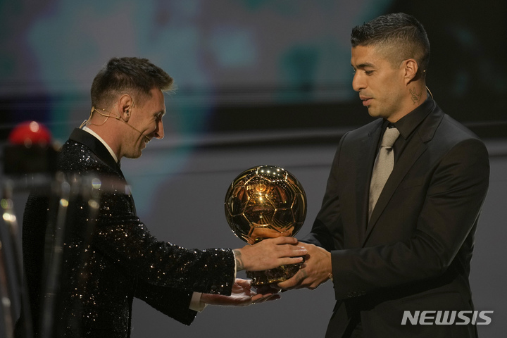 [파리=AP/뉴시스]리오넬 메시의 바르셀로나 시절 동료였던 루이스 수아레스가 발롱도르 트로피를 전달하고 있다. 2021.11.29.