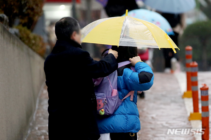 [서울=뉴시스] 지난해 11월30일 오전 서울 종로구 청운초등학교에서 학부모가 자녀에게 가방을 메주고 있다. (사진=뉴시스DB). 2022.02.21. photo@newsis.com
