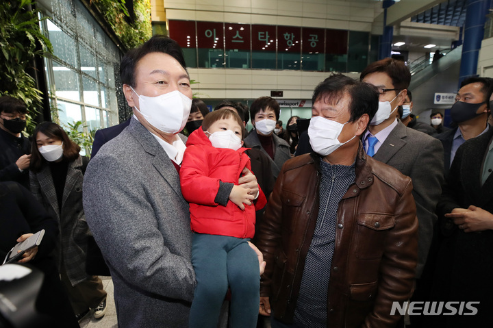 [청주=뉴시스] 전신 기자 = 윤석열 국민의힘 대선 후보가 30일 청주국제공항을 방문해 어린이와 기념촬영하고 있다. 2021.11.30. photo1006@newsis.com