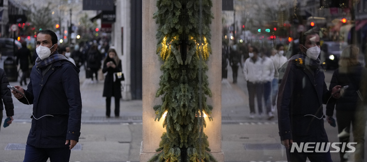 [런던(영국)=AP/뉴시스] 30일(현지시간) 영국 런던 시내에서 시민들이 마스크를 쓴 채 걷고 있다. 2021.12.01.