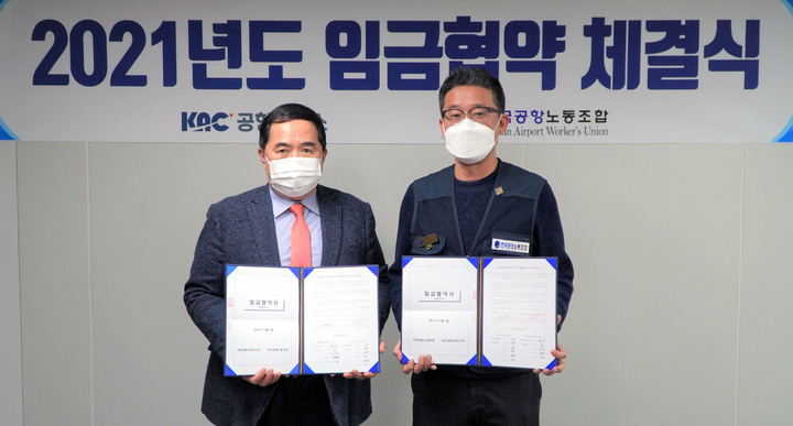 [서울=뉴시스] 홍찬선 기자 = 한국공항공사의 자회사인 KAC 공항서비스 노사는 1일 오전 서울 강서구 본사 대회의실에서 2021년 임금협약 체결식을 열고 기본급 4% 인상안에 합의했다. 사진은 이날 체결식에서 김금렬(왼쪽) KAC공항서비스 사장과 엄흥택 전국공항노조 위원장이 입금협약서를 들고 기념찰영하고 있다. (사진=KAC 공항서비스 제공) photo@newsis.com *재판매 및 DB 금지
