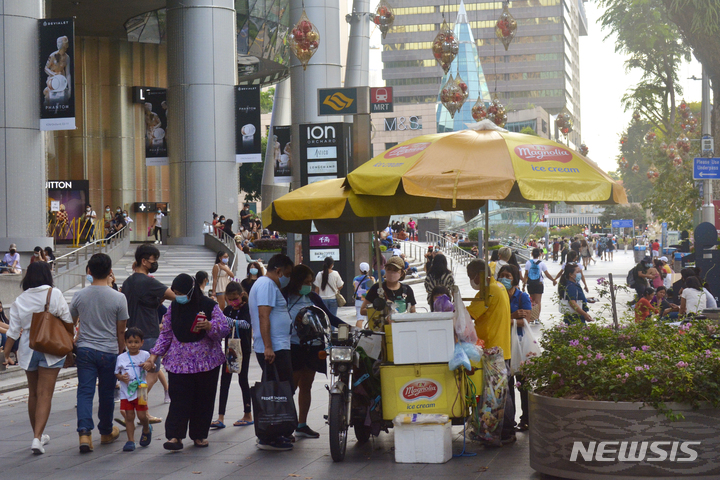 [싱가포르=AP/뉴시스] 11월28일(현지시간) 마스크를 쓴 사람들이 싱가포르 오차드 로드 쇼핑 거리를 걷고 있다. 2021.12.01