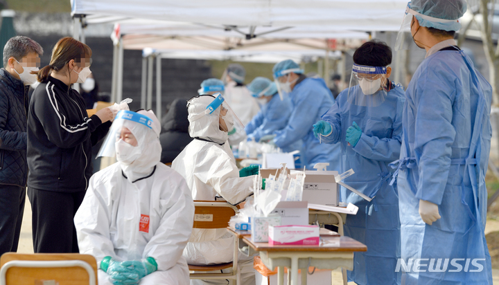 [광주=뉴시스] 류형근 기자 = 지난 3일 오전 광주의 모 고등학교 운동장에서 방역당국이 학생들을 대상으로 코로나19 검사를 하고 있다. 2021.12.03. hgryu77@newsis.com