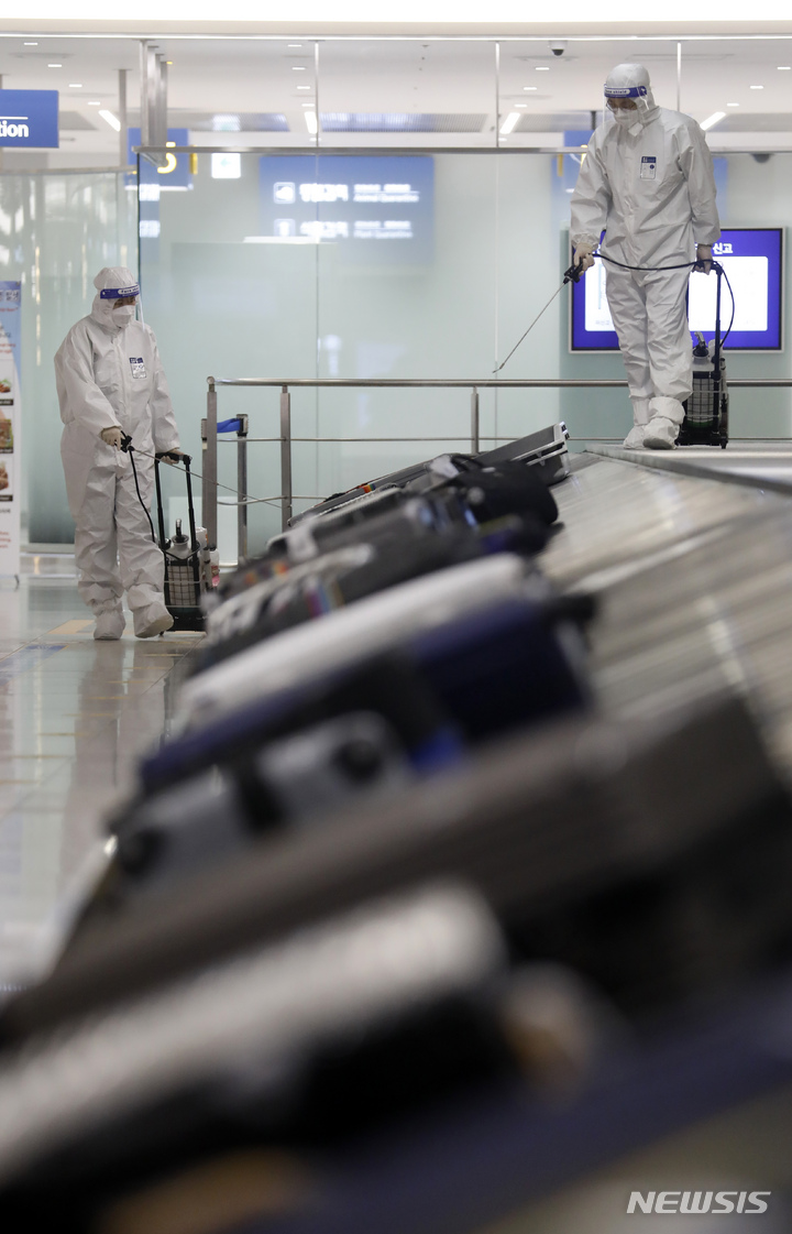 [인천공항=뉴시스] 고승민 기자 = 코로나19 오미크론 변이 바이러스 유입으로 방역에 비상이 걸린 3일 인천국제공항 제1터미널 세관구역 수하물 컨베이어 벨트에서 공항 관계자들이 방역을 하고 있다. 2021.12.03. kkssmm99@newsis.com