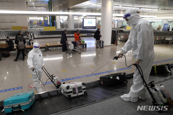 [인천공항=뉴시스] 고승민 기자 = 코로나19 오미크론 변이 바이러스 유입으로 방역에 비상이 걸린 3일 인천국제공항 제1터미널 세관구역 수하물 컨베이어 벨트에서 공항 관계자들이 방역을 하고 있다. 2021.12.03. kkssmm99@newsis.com