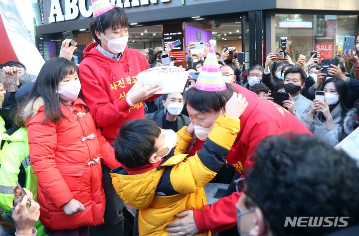 고[부산=뉴시스] 하경민 기자 = 국민의힘 윤석열 대선 후보가 이준석 당 대표와 함께 4일 부산 부산진구 서면 일대에서 선거운동을 펼치던 중 '오늘부터 딱 95일! 단디 하자'라고 적힌 케익을 선물받은 뒤 고깔을 쓰 있다. 2021.12.04. yulnetphoto@newsis.com