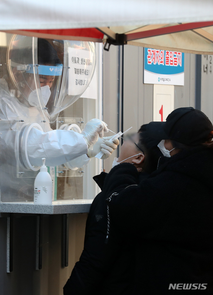 [인천= 뉴시스] 백동현 기자 = 코로나19 신규 확진자가 4,325명으로 집계된 6일 오전 인천 미추홀구보건소 선별진료소에서 의료진이 검체를 채취하고 있다. 2021.12.06. livertrent@newsis.com