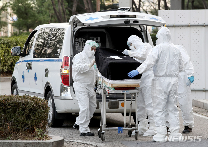 [서울=뉴시스] 김병문 기자 = 지난 6일 오후 서울 중랑구 서울특별시 서울의료원에서 의료진과 장의사가 코로나19로 사망한 고인의 시신을 차량으로 옮기고 있다. 중앙사고수습본부(중수본)에 따르면 전날 오후 5시 기준 수도권의 코로나19 중환자 병상 가동률은 86.6%로 총 병상 794개 중 688개가 사용 중이다. 2021.12.06. dadazon@newsis.com