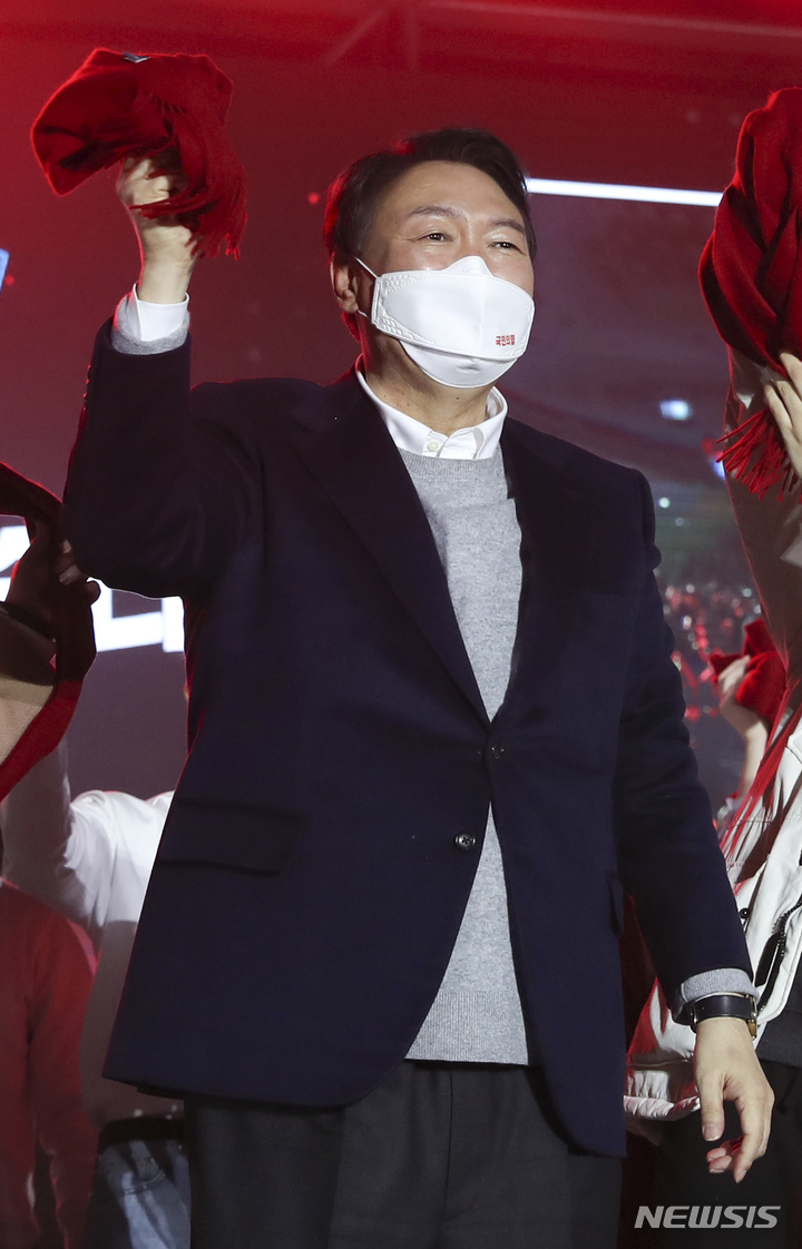 [서울=뉴시스] 국회사진기자단 = 윤석열 국민의힘 대선 후보가 6일 서울 송파구 올림픽공원 체조경기장에서 열린 제20대 대통령선거 중앙선거대책위원회 출범식에서 빨간 목도리를 들고 청년들과 대선 승리 기원 퍼포먼스를 하고 있다. 오른쪽은 김종인 총괄선대위원장. 2021.12.06. photo@newsis.com