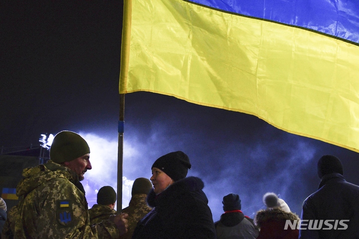 [크라마토르스크=AP/뉴시스] 우크라이나 군인들이 6일(현지시간) 우크라이나 도네츠크주 크라마토르스크에서 우크라이나군 창설 30주년 기념 행진을 앞둔 한 병사가 우크라이나 국기를 든 한 여성과 얘기하고 있다. 우크라이나는 6일 군 창설 30주년인 국군의 날을 맞이했다. 2021.12.07.