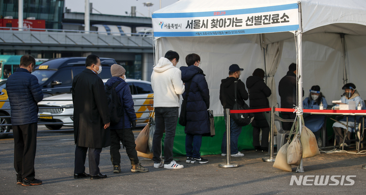 [서울=뉴시스] 정병혁 기자 = 0시 기준 국내 코로나19 신규 확진자가 4954명으로 집계된 7일 오전 서울 강서구 김포국제공항 국내선 주차장에 설치된 서울시 찾아가는 선별진료소를 찾은 시민들이 검사를 받기 위해 줄 서 있다. 2021.12.07. jhope@newsis.com