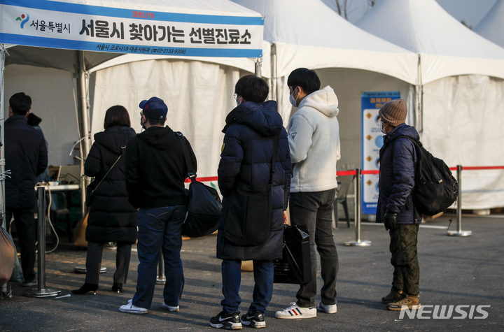 [서울=뉴시스] 정병혁 기자 = 0시 기준 국내 코로나19 신규 확진자가 4954명으로 집계된 7일 오전 서울 강서구 김포국제공항 국내선 주차장에 설치된 서울시 찾아가는 선별진료소를 찾은 시민들이 검사를 받기 위해 줄 서 있다. 2021.12.07. jhope@newsis.com