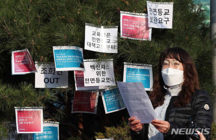 서울=뉴시스] 이영환 기자 = 김나형 서울시학부모연합 전 대표가 7일 오전 서울 종로구 서울시교육청 앞에서 서울시학부모연합 소속 학부모들이 백신패스 철회 촉구 기자회견에 참석해 발언을 하는 가운데 학부모들이 게시한 피켓이 게시되어 있다. 2021.12.07. 20hwan@newsis.com