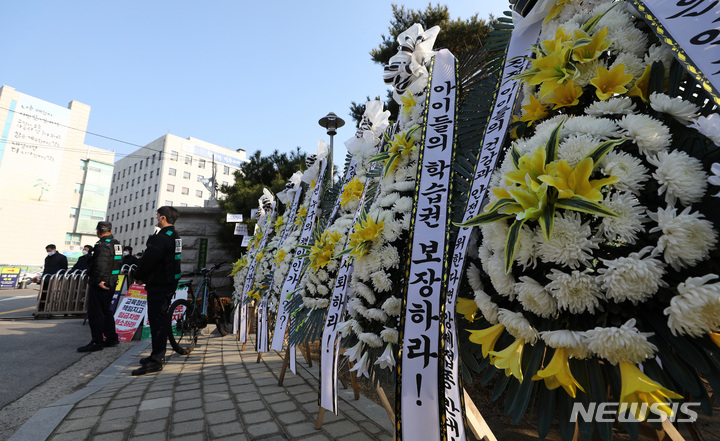 [서울=뉴시스] 이영환 기자 =  7일 오전 서울 종로구 서울시교육청 앞에 청소년 방역패스를 규탄하는 근조화환이 설치되고 있다. 2021.12.07. 20hwan@newsis.com