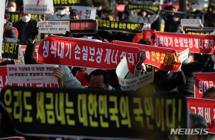 [서울=뉴시스] 이영환 기자 = 8일 오후 서울 영등포구 국회의사당역 인근에서 열린 코로나19 피해 실질 보상 촉구 정부·여당 규탄대회에서 참석자들이 구호를 외치고 있다. 2021.12.08. 20hwan@newsis.com