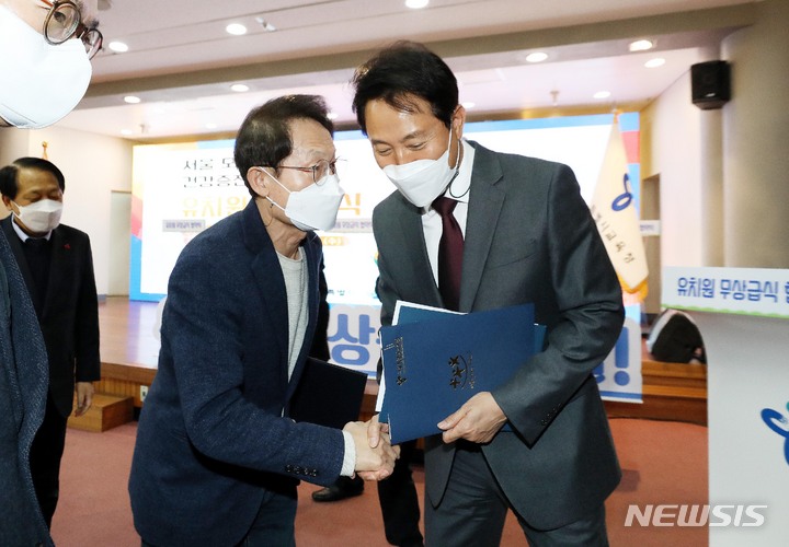 [서울=뉴시스] 김병문 기자 = 조희연(왼쪽) 서울교육감과 오세훈 서울시장이 8일 오후 서울 종로구 서울시교육청 강당에서 유치원 무상급식 업무협약을 체결한 뒤 인사를 나누고 있다. (공동취재사진) 2021.12.08. photo@newsis.com