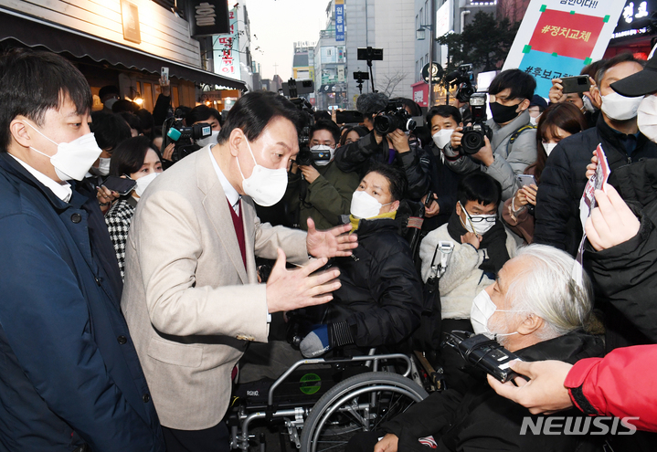 [서울=뉴시스] 국회사진기자단 = 윤석열 국민의힘 대선 후보와 이준석 대표가 8일 서울 종로구 대학로에서 청년문화예술인 간담회 후 장애인 단체 대표들과 이야기를 하고 있다. 2021.12.08. photo@newsis.com