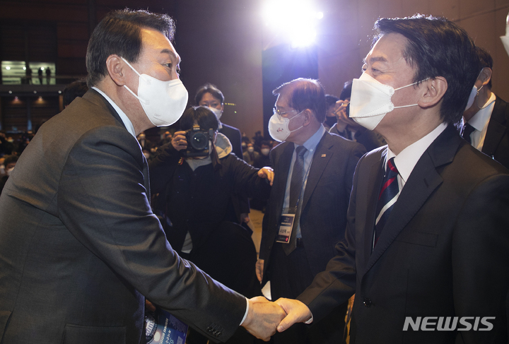 [서울=뉴시스] 국회사진기자단 = 10일 오후 서울 강남 코엑스 전시장 D홀에서 열린 ‘사회복지 비전선포대회’에서 국민의힘 윤석열(왼쪽) 대선후보와 국민의당 안철수 대선 후보가 악수를 하고 있다. 2021.12.10. photo@newsis.com