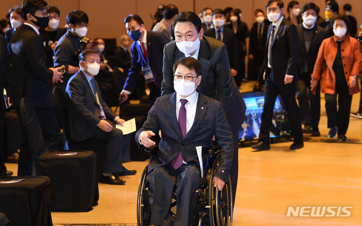 [서울=뉴시스] 국회사진기자단 = 국민의힘 윤석열 대선 후보가 10일 서울 강남구 코엑스에서 열린 사회복지비전선포대회에서 국민의힘 이종성 의원의 휠체어를 밀며 함께 입장하고 있다. 2021.12.10. photo@newsis.com