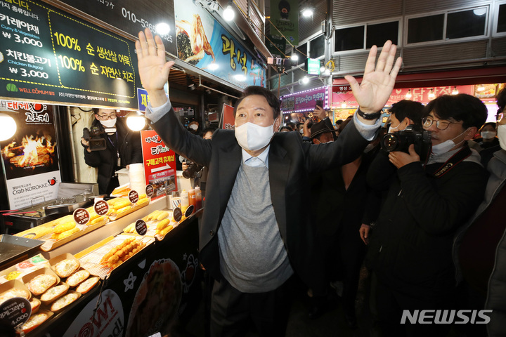 [강릉=뉴시스] 전신 기자 = 윤석열 국민의힘 대선 후보가 10일 강원도 강릉 중앙시장을 방문해 시민들을 향해 인사하고 있다. 2021.12.10. photo1006@newsis.com