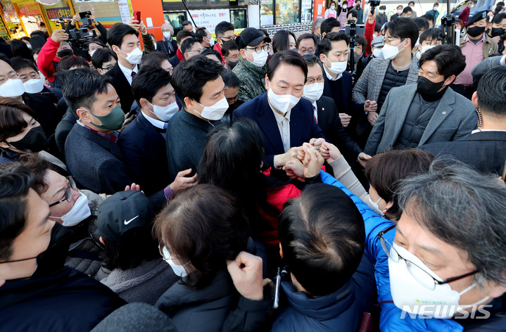 [속초=뉴시스] 전신 기자 = 윤석열 국민의힘 대선 후보가 11일 강원도 속초 대포항 수산시장을 방문해 시민들과 인사하고 있다. (공동취재사진) 2021.12.10. photo@newsis.com