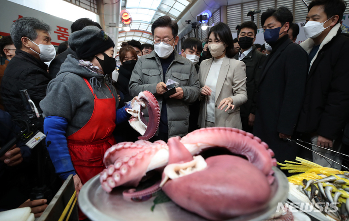 [안동=뉴시스] 최동준 기자 = 이재명 더불어민주당 대선 후보, 부인 김혜경 씨가 11일 경북 안동 중앙신시장을 방문해 문어를 구매하고 있다. (공동취재사진) 2021.12.11. photo@newsis.com