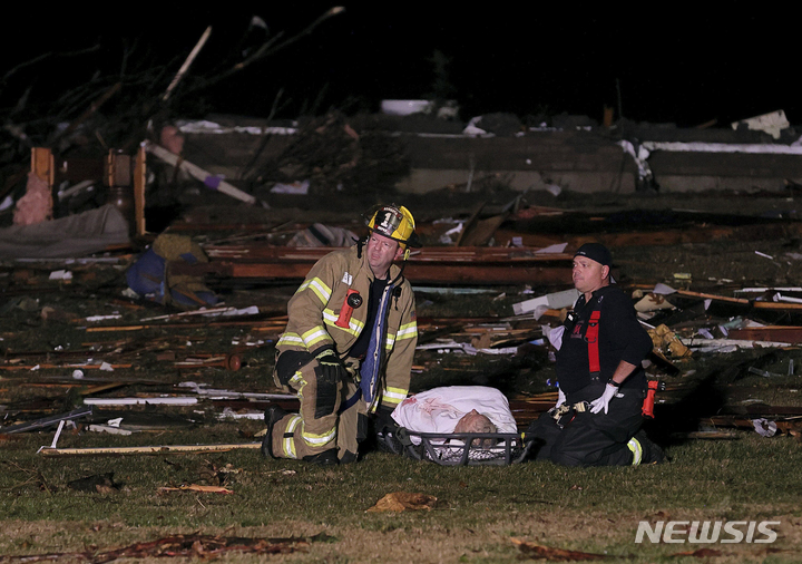 [세인트 찰스=AP/뉴시스] 11일(현지시간) 미주리주 세인트 찰스 카운티 고속도로 주변에서 소방대원들이 토네이도로 무너진 집에서 발견된 부상자를 돌보며 구급차가 오기를 기다리고 있다. 지난 10일 밤 아칸소, 일리노이, 켄터키, 미주리, 테네시, 미시시피 등 6개 주에서 최소 30개의 토네이도가 발생해 켄터키주에서만 최소 70명이 숨진 것으로 나타났다. 2021.12.12. 