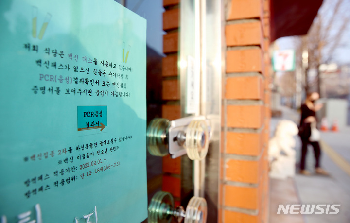 [서울=뉴시스] 김병문 기자 = 식당·카페 등 다중이용시설 16종에 적용하는 방역패스(접종증명·음성확인) 계도기간 종료일인 지난 12일 오전 서울 종로구 한 식당에 백신패스 관련 안내문이 부착돼 있다. 2021.12.12. dadazon@newsis.com