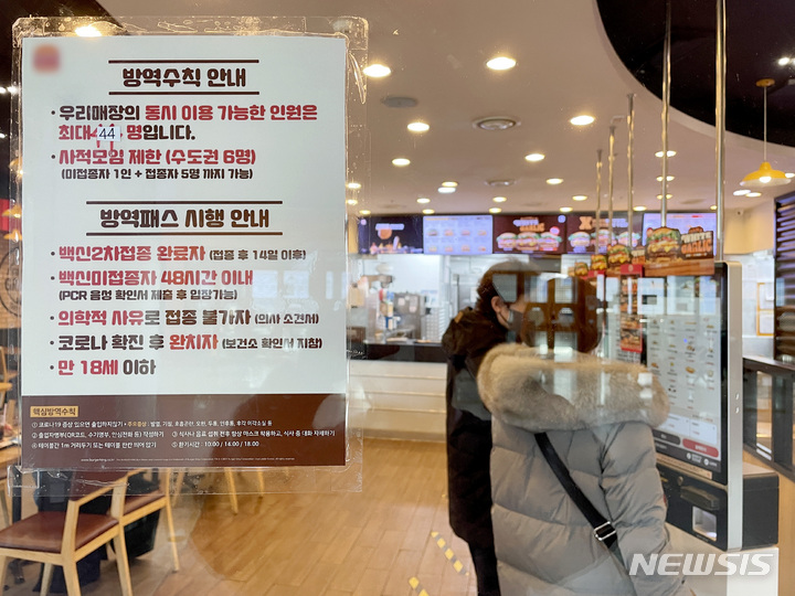 [서울=뉴시스] 김병문 기자 = 식당·카페 등 다중이용시설 16종에 적용하는 방역패스(접종증명·음성확인) 계도기간 종료일인 12일 오전 서울 시내 한 식당에 방역패스 안내문이 부착돼 있다. 2021.12.12. dadazon@newsis.com