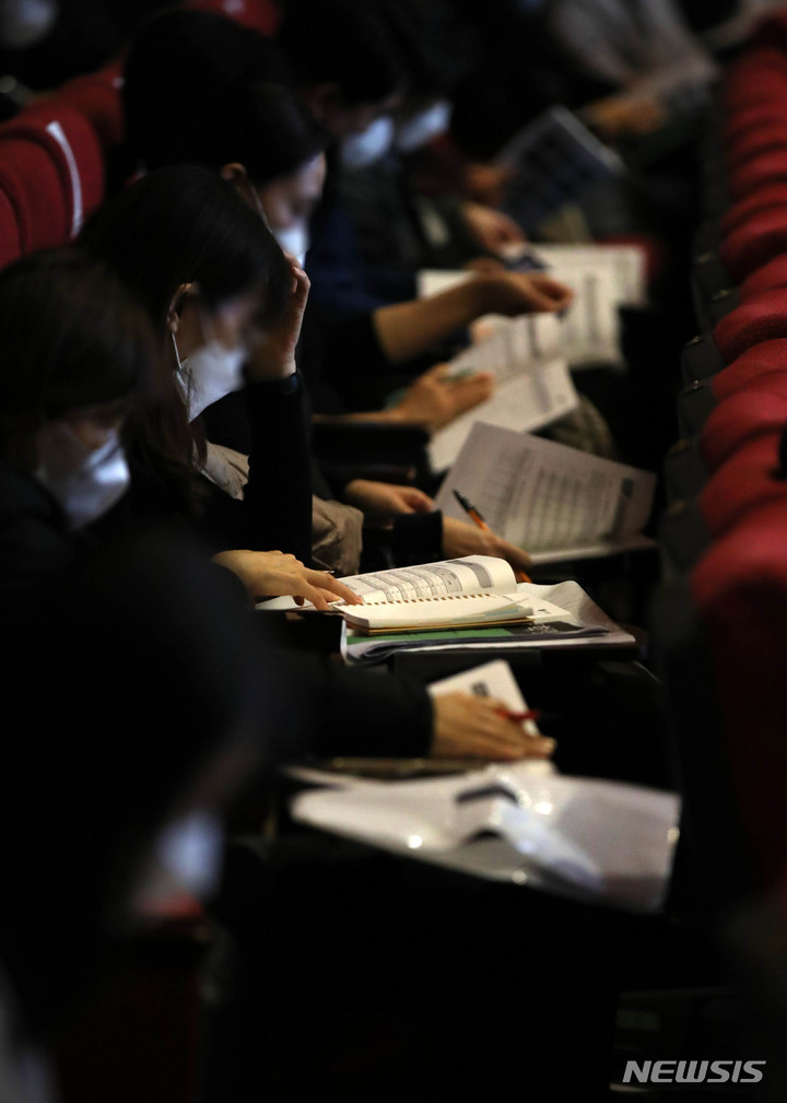 [서울=뉴시스] 고범준 기자 = 12일 오후 서울 종로구 성균관대학교 새천년홀에서 열린 종로학원 2022대입 정시특별전략 설명회를 찾은 학부모와 학생들이 2022 정시모집 배치참고표를 살펴보고 있다. 2021.12.12. bjko@newsis.com