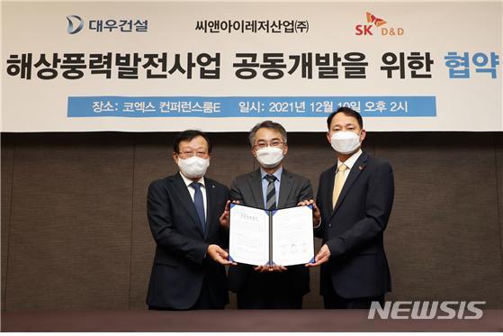 [서울=뉴시스] 대우건설 신사업본부장 김창환 전무, 씨앤아이레저산업 이상룡 대표이사, SK디앤디 김해중 에너지솔루션본부장이 서울 삼성동 코엑스에서 굴업도 해상풍력발전사업을 위한 공동개발 업무협약을 체결하고 기념사진을 촬영하고 있다. (사진=대우건설 제공)