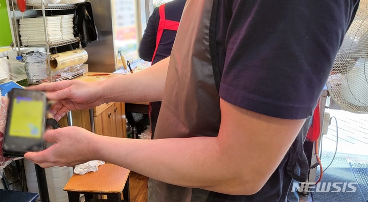 [대구=뉴시스] 고여정 수습기자 = 방역패스 계도기간이 끝난 13일 오전 대구 중구의 한 식당에서 백신접종 증명서를 확인하고 있다. 2021.12.13 ruding@newsis.com