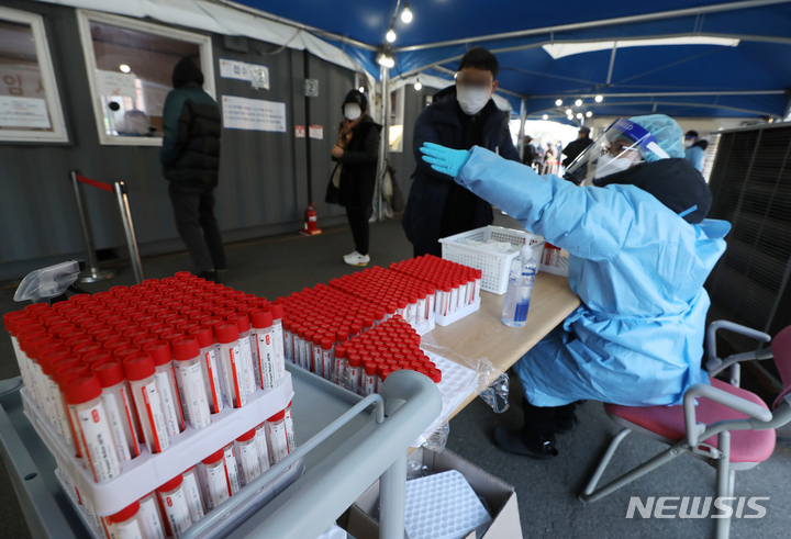 [서울=뉴시스] 조수정 기자 = 0시 기준 코로나19 신규확진자 수가 5817명으로 집계된 13일 오전 서울 중구 서울역광장 코로나19 임시선별검사소에서 시민들이 검사를 받기 위해 검사 키트를 받고 있다. 2021.12.13. chocrystal@newsis.com