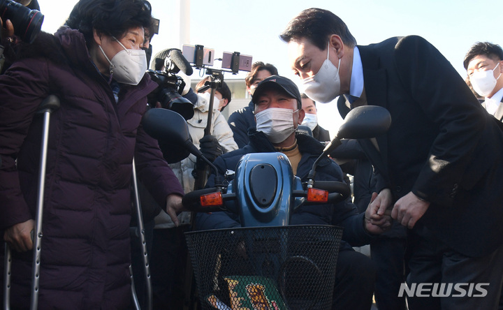 [서울=뉴시스] 최진석 기자 = 윤석열 국민의힘 대선후보가 13일 서울 여의도 국회 본관 앞에서 중앙선대위 장애인복지지원본부가 개최한 전국 릴레이정책투어 '장문현답(장애인 문제의 답은 현장에 있다)' 출정식에 참석해 참석자들과 대화를 나누고 있다. (공동취재사진) 2021.12.13. photo@newsis.com