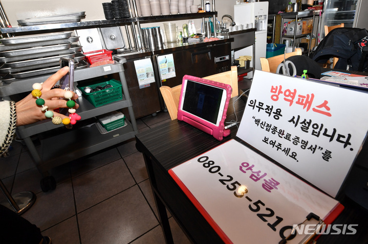 [광주=뉴시스] 변재훈 기자 = '방역패스'(접종증명·음성확인제)' 의무화가 확대된 13일 광주 북구 모 식당에서 한 손님이 QR코드를 통한 코로나19 예방 백신 접종 인증을 하고 있다. 2021.12.13. wisdom21@newsis.com