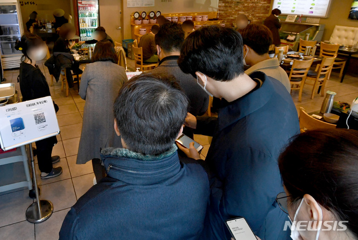 [광주=뉴시스] 변재훈 기자 = '방역패스'(접종증명·음성확인제)' 의무화가 확대된 13일 광주 북구 모 식당에서 손님들이 코로나19 예방 백신 접종 인증 절차를 준비하고 있다. 2021.12.13. wisdom21@newsis.com