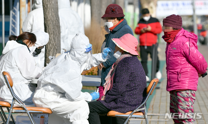 [함평=뉴시스] 류형근 기자 = 전남 함평 지역 어린이집교사 등 3명이 코로나19 변이 바이러스 오미크론에 감염된 가운데 13일 오전 전남 함평군 함평읍 함평엑스포공원 주차장에서 방역당국이 주민을 대상으로 전수검사를 하고 있다. 2021.12.13. hgryu77@newsis.com