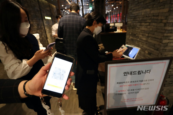 [부산=뉴시스] 하경민 기자 = '방역패스'(접종증명·음성확인제)' 의무화가 본격적으로 시행된 13일 부산 해운대구의 한 백화점 내 음식점 입구에서 손님들이 QR코드 확인을 통한 코로나19 백신 접종 완료를 인증하고 있다. 2021.12.13. yulnetphoto@newsis.com