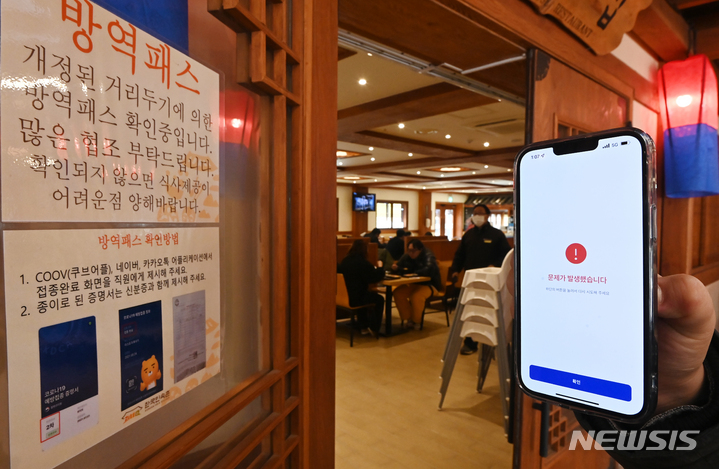 [용인=뉴시스] 김종택기자 = 방역패스 의무화가 시작된 13일 경기도 용인시 기흥구 한 식당 이용자들의 휴대폰에 쿠브(COOV·전자예방접종증명서)애플리케이션 오류 메시지가 나오고 있다. 2021.12.13.jtk@newsis.com
