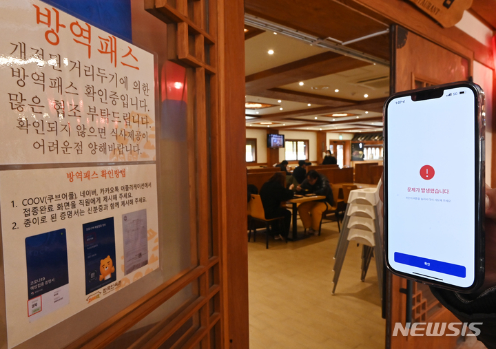 [용인=뉴시스] 김종택기자 = 방역패스 의무화가 시작된 13일 경기도 용인시 기흥구 한 식당 이용자들의 휴대폰에 쿠브(COOV·전자예방접종증명서)애플리케이션 오류 메시지가 나오고 있다. 2021.12.13. jtk@newsis.com