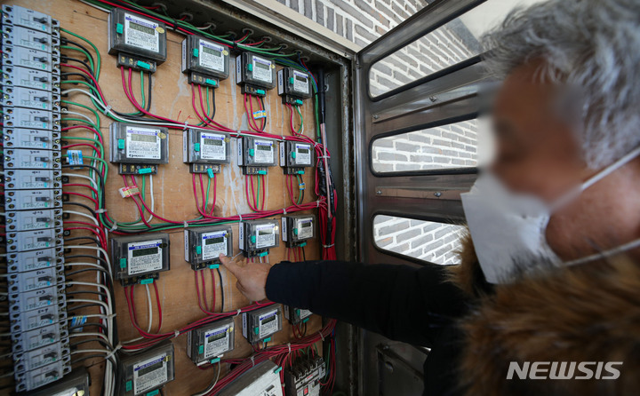 [서울=뉴시스] 권창회 기자 = 13일 오후 서울 시내 한 주택단지에 주민이 전기계량기를 살펴보고 있다. 2021.12.13. kch0523@newsis.com