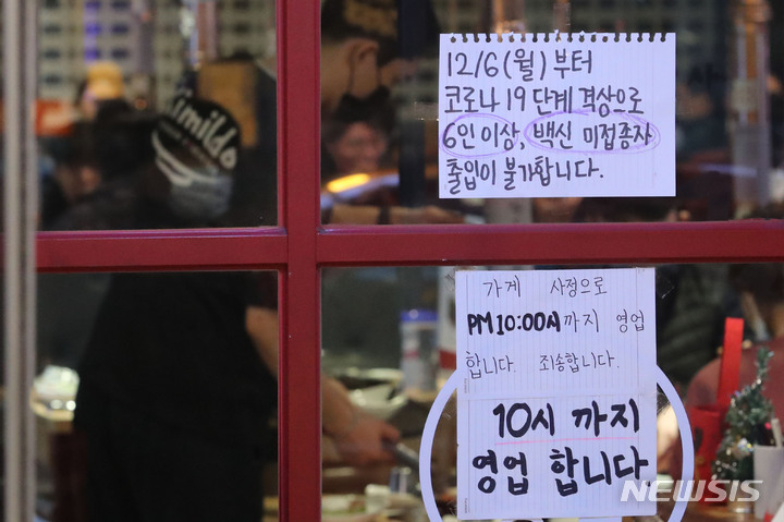 [서울=뉴시스] 권창회 기자 = 다중이용시설 방역패스 의무화가 시작된 지난 13일 밤 서울 시내 한 식당에 방역패스 관련 안내문이 붙어있다. 2021.12.13. kch0523@newsis.com