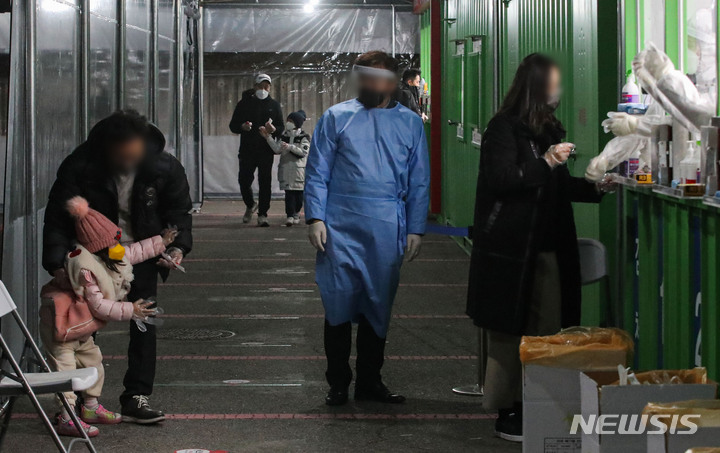 [서울=뉴시스] 권창회 기자 = 코로나19 신규 확진자가 5,817명으로 집계된 13일 밤 서울 송파구잠실종합운동장 제2주차장에 설치된 서울시 코로나19 검사소에서 한 아이가 검사를 피하고 있다. 2021.12.13. kch0523@newsis.com