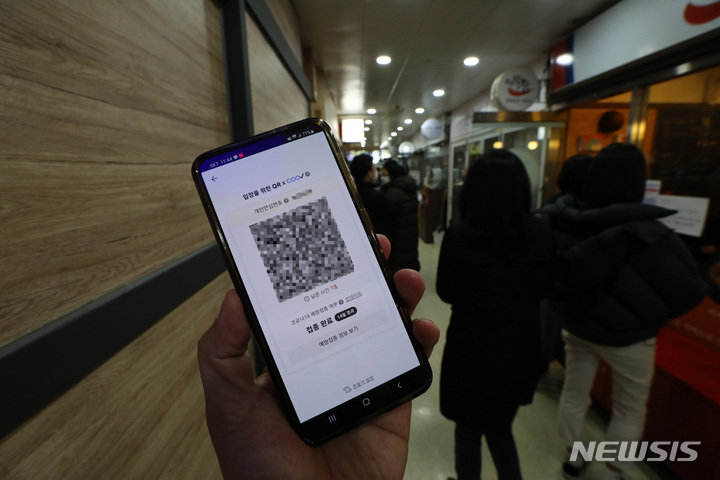 [서울=뉴시스] 이영환 기자 = 방역패스 의무화 시행 이틀째인 지난 14일 서울 시내의 한 식당 앞에서 실행시킨 QR 코드가 정상 작동되고 있다. 2021.12.14. 20hwan@newsis.com